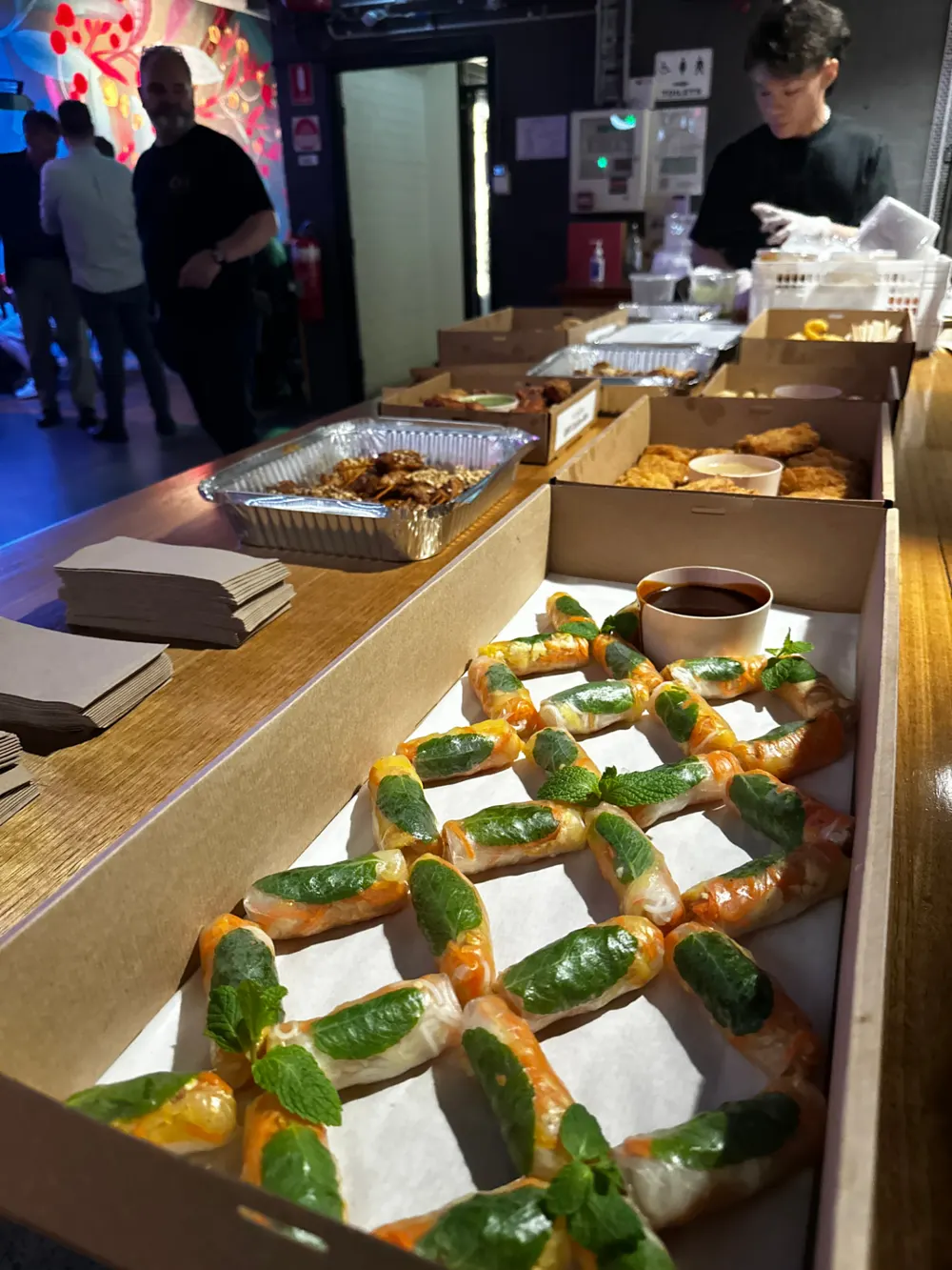 Boxes of fresh rice paper rolls and fried bites laid out for a catered event