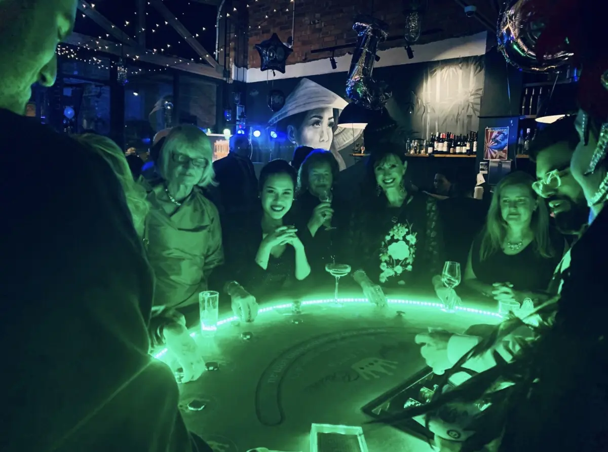 Guests gathered around a lit casino table at a Mister Minh party